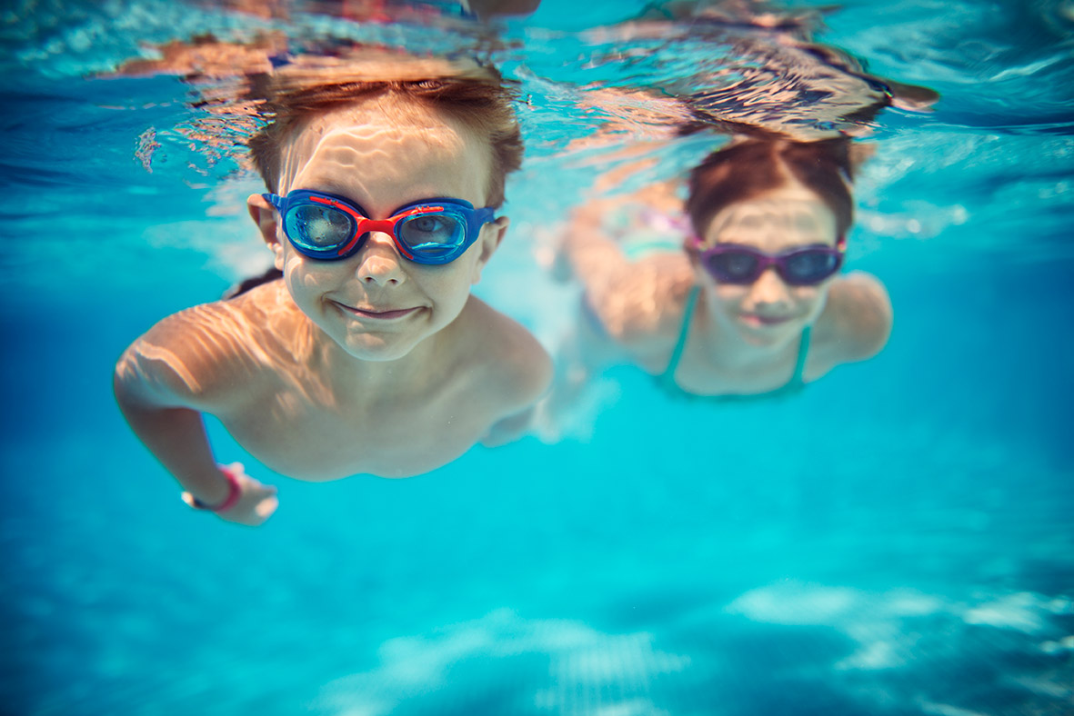 2 Kinder die in einem Pool schwimmen.